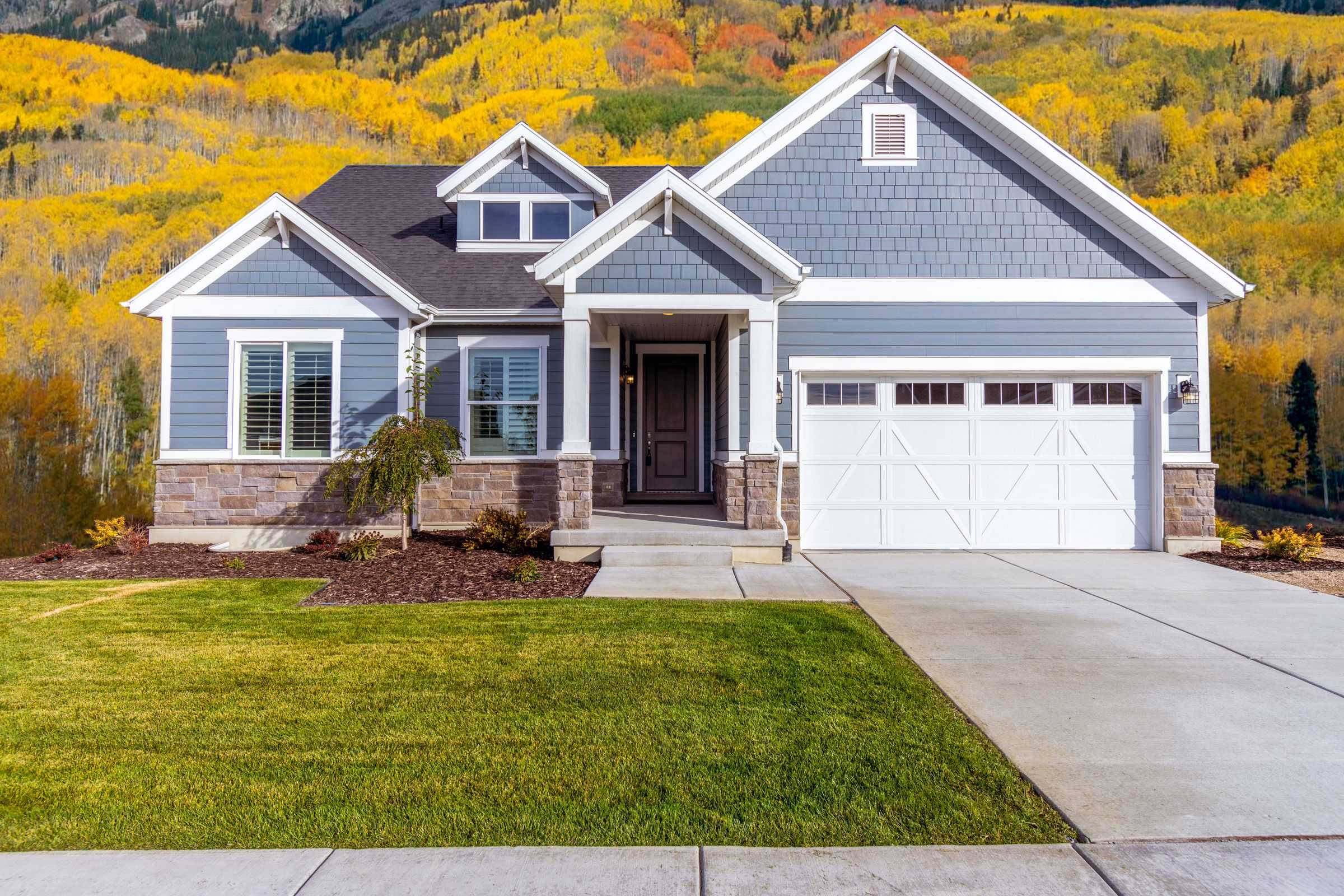 Blue craftsman home surrounded by golden aspen trees