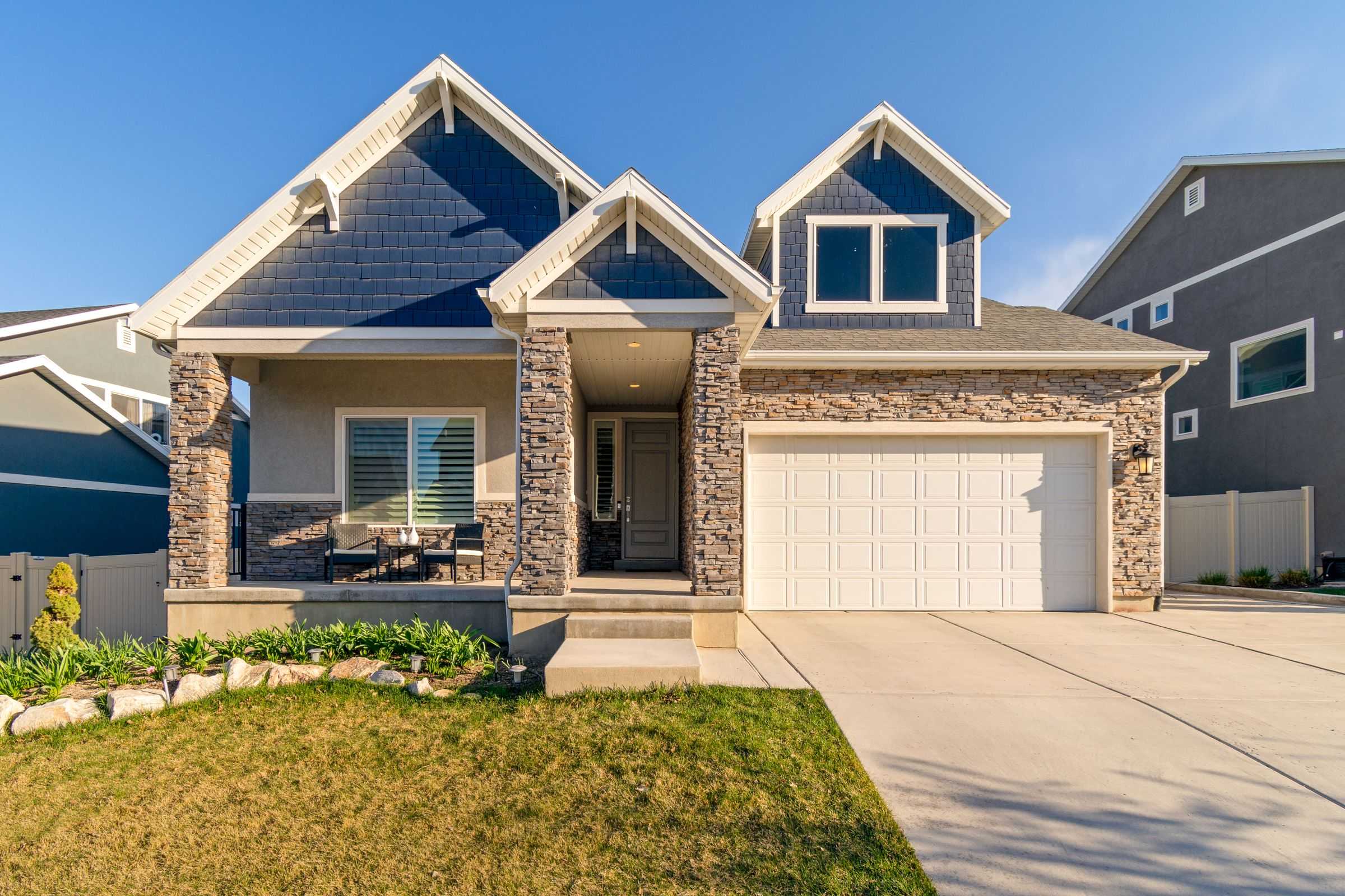 Stone-and-shingle home with a landscaped front yard